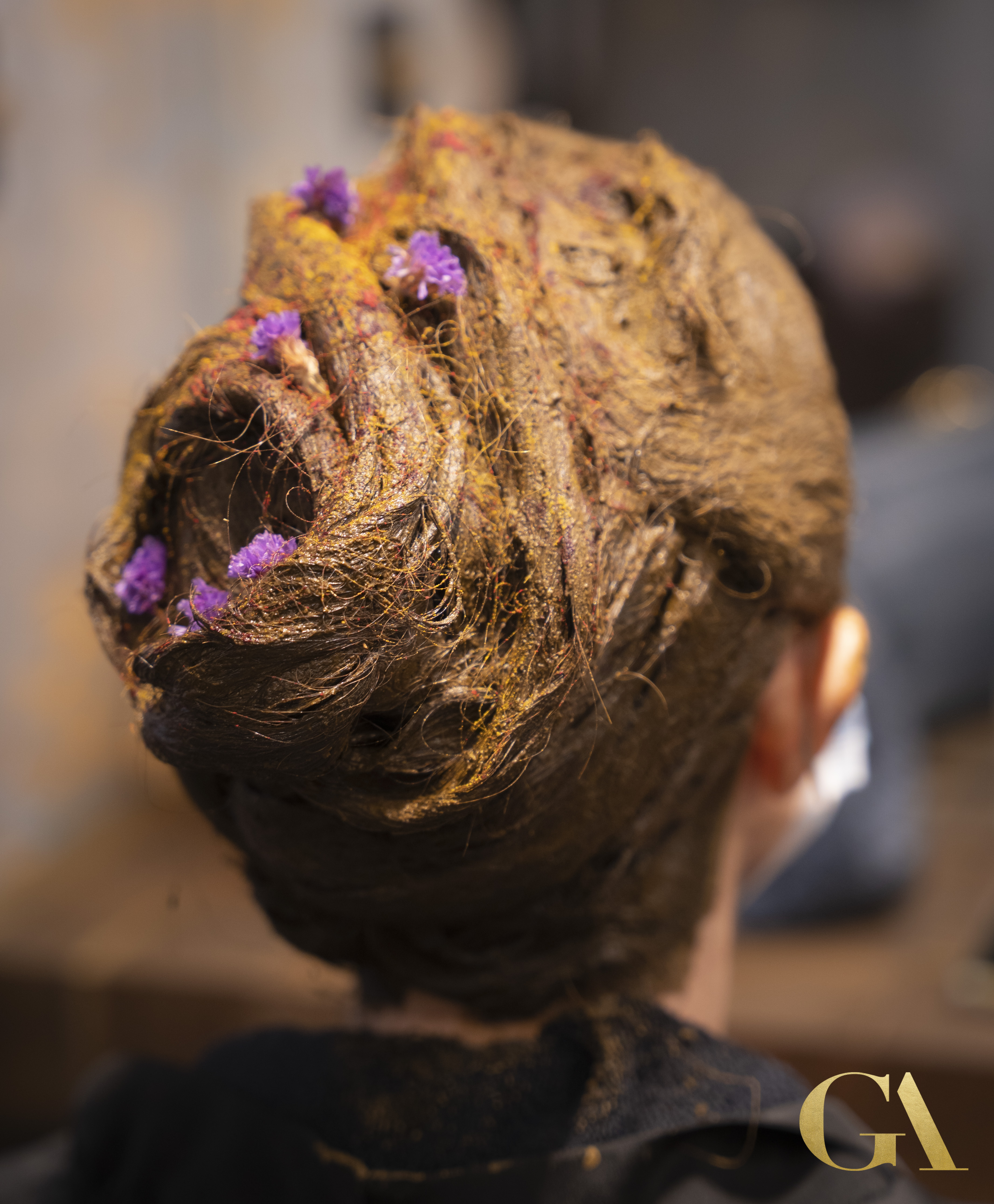 Natural herbal hair spa treatment with golden turmeric and purple flowers at GA Salons