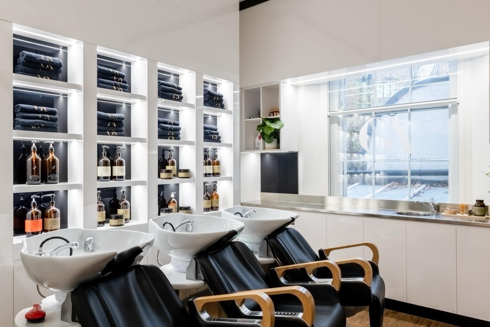 Area lavaggio capelli con asciugamani neri di lusso e prodotti premium